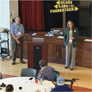 Two people presenting in front of an audience.