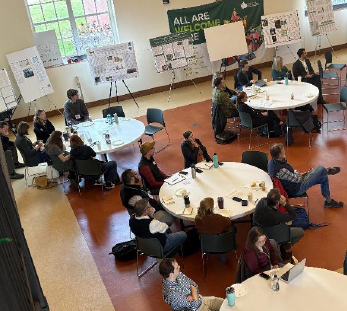 Overhead view of three round tables with people sitting around them.